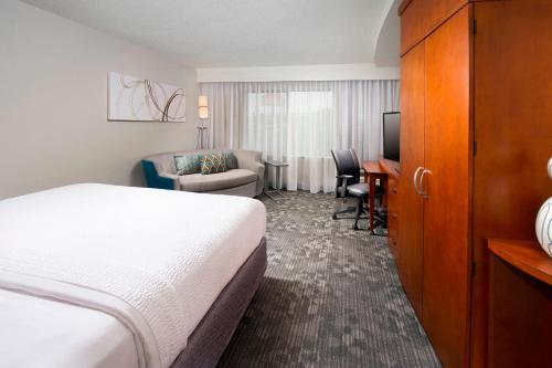 a hotel room with a bed and a living room at Courtyard by Marriott San Antonio SeaWorld/Lackland in San Antonio