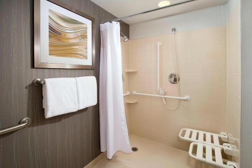 a bathroom with a shower and a white shower curtain at Courtyard by Marriott San Antonio SeaWorld/Lackland in San Antonio