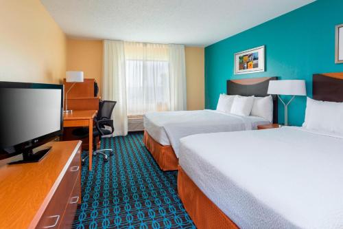 a hotel room with two beds and a flat screen tv at Fairfield Inn & Suites Tyler in Tyler