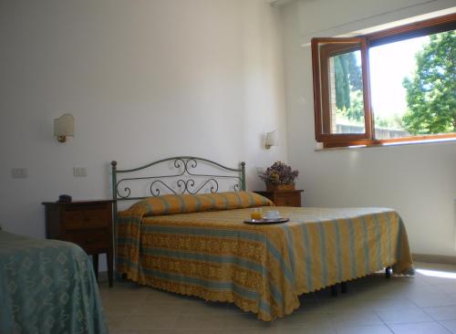 1 dormitorio con cama y ventana en Hotel I Platani, en Siena