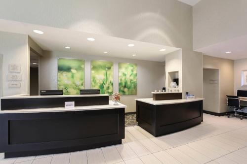 オクラホマシティにあるSpringHill Suites by Marriott Oklahoma City Quail Springsのロビーにはフロントデスク付きの待合室があります。