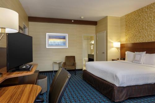 a hotel room with a bed and a desk and a television at Fairfield Inn & Suites by Marriott Belleville in Belleville