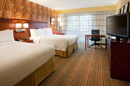 SorrentoにあるCourtyard by Marriott San Diego Sorrento Valleyのベッド2台、薄型テレビが備わるホテルルームです。
