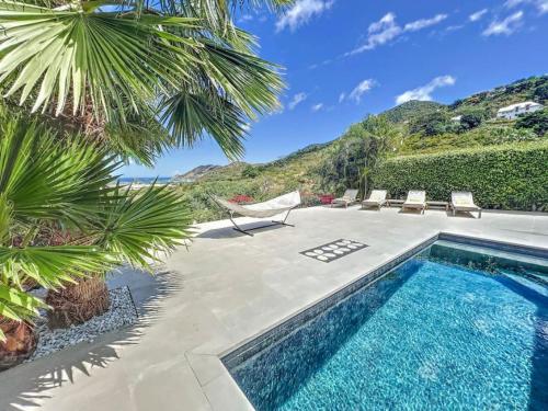 Villa les Yuccas, private pool, 5 min from Grand Case في سانت مارتن: مسبح في ساحة فيها كراسي واشجار