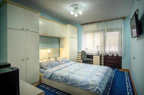 a bedroom with a bed and a desk and a window at Евтини апартаменти и стаи до морето-Варна-Евксиноград-до DENTAPRIME in St. St. Constantine and Helena