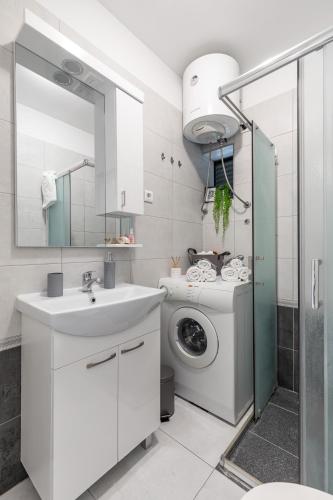 a bathroom with a sink and a washing machine at Cool Suite in Split