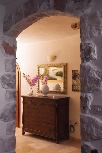 a room with a dresser and a mirror on a wall at Masseria Montanaro in Cisternino