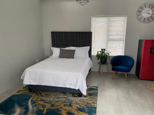 a bedroom with a large bed and a blue chair at Studio On Nate in Mount Pleasant