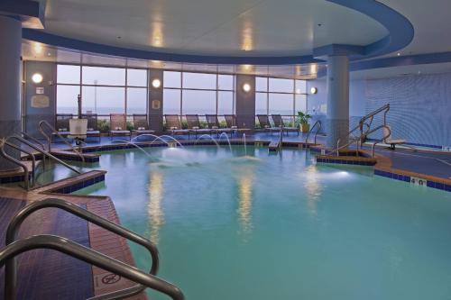 a large swimming pool with blue water in a building at SpringHill Suites by Marriott Virginia Beach Oceanfront in Virginia Beach