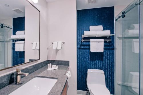 a bathroom with a sink and a toilet and a mirror at Fairfield Inn by Marriott New York LaGuardia Airport/Astoria in Queens