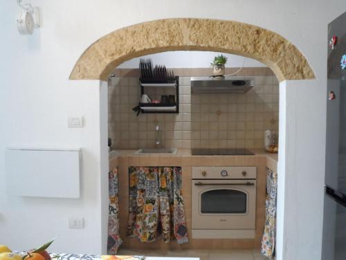 un arco in una cucina con piano cottura e forno di Casa Bianca a Gagliano del Capo