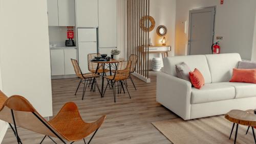 a living room with a couch and a table and chairs at Shellter Apartments by the sea in Vieira de Leiria