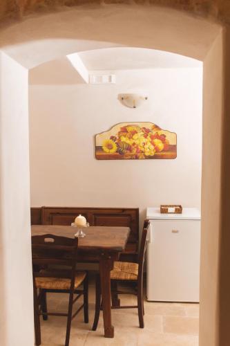a dining room table and chairs with a painting on the wall at Masseria Montanaro in Cisternino