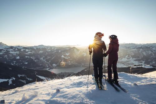 two people on skis standing on top of a mountain at Pension Monika, Cozy B&B, newly renovated rooms in Kaprun in Kaprun