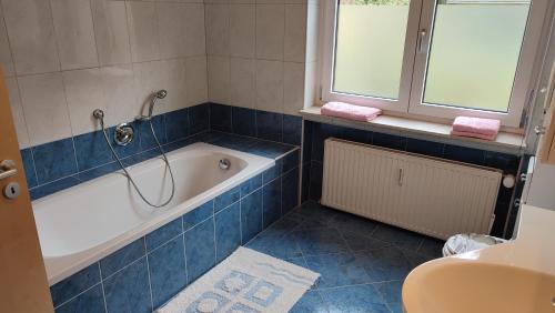 a bathroom with a bath tub and a window at Leimbach in Bad Brückenau