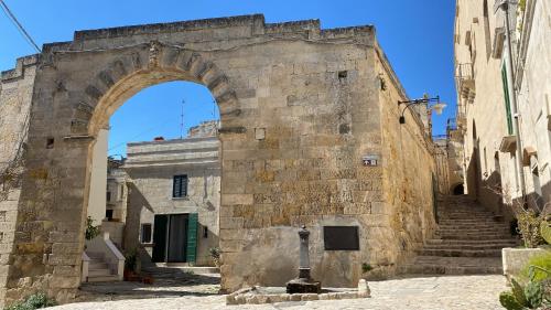 een boog in een stenen gebouw met trappen bij La Luna nei Sassi in Matera
