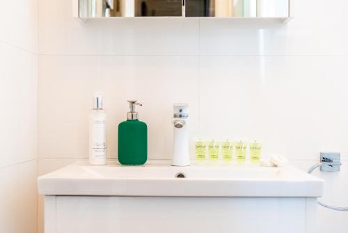 un lavandino in bagno con una bottiglia verde di Pass the Keys Stunning House in Walthamstow a Londra
