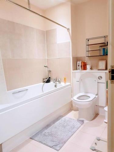 a bathroom with a tub and a toilet and a sink at Central spacious and secure with a double bed in Colindale