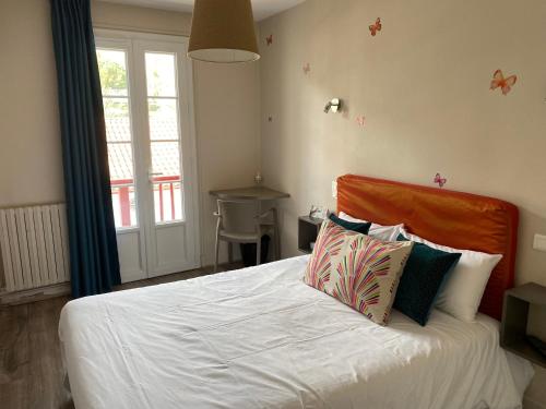 a bedroom with a bed with white sheets and pillows at Hôtel Juantorena in Saint-Étienne-de-Baïgorry