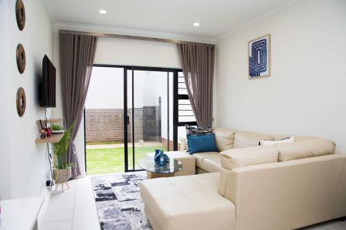 a living room with a white couch and a large window at Secured and Fully equipped apartment- E in Lombardy East