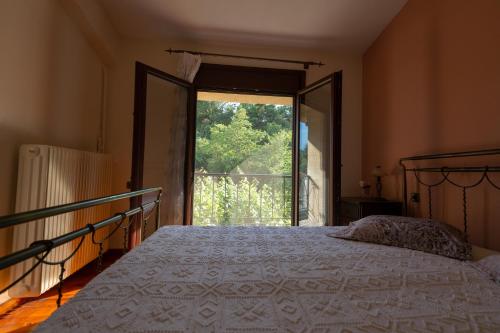 a bedroom with a bed and a large window at Konaki Polinas in Kanália