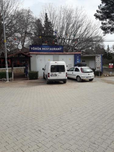 two cars parked in a parking lot in front of aoren restaurant at KARAVAN in Kemer