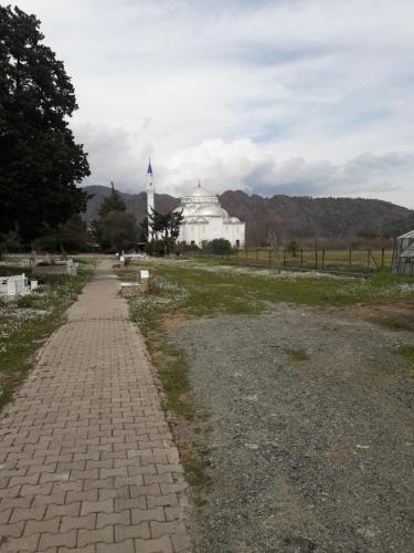 um caminho de tijolos em frente a um edifício branco em KARAVAN em Kemer