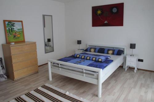 a bedroom with a bed with blue pillows and a dresser at Gästewohnung Pakulies in Weinheim