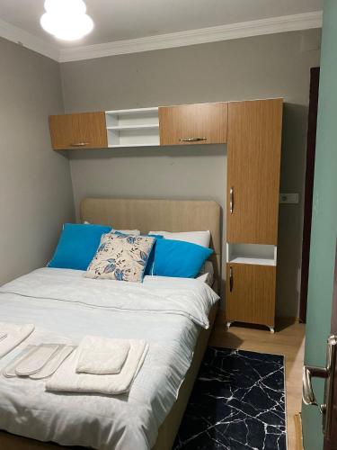 a bedroom with a bed with blue pillows and a cabinet at ortaköy ev daire in Istanbul
