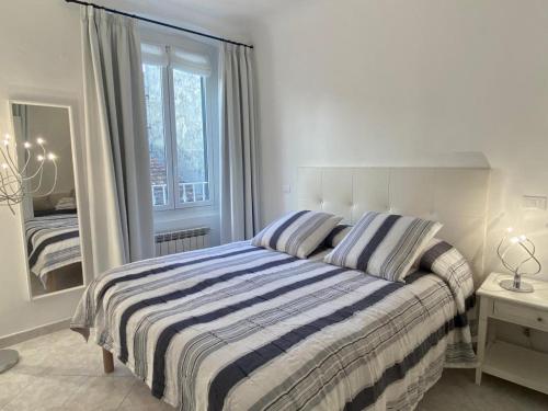 レーリチにあるCasa Vacanze Armandaのベッドルーム1室(ストライプ毛布と鏡付きのベッド1台付)