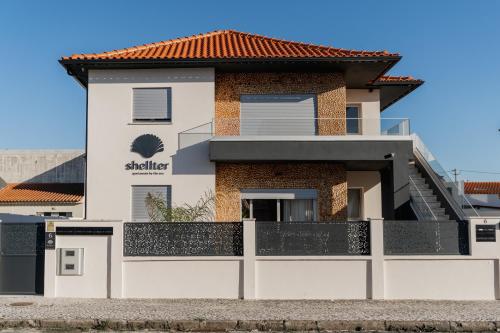 a white house with a red roof at Shellter Apartments by the sea in Vieira de Leiria