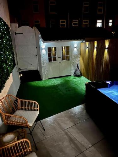 a green floor in a room with a bed and a chair at Luxe City Hot Tub: Urban Retreat in Norwich