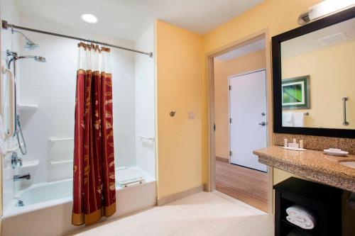 a bathroom with a tub and a shower at Courtyard by Marriott Miami Homestead in Homestead