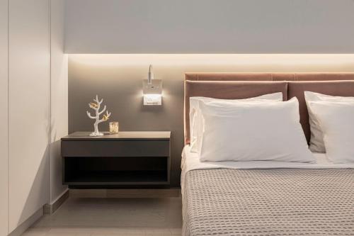 a bedroom with a bed with a nightstand next to it at Chania City Luxury Dreams Apartment in the Heart of Chania in Chania
