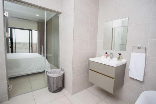y baño con lavabo y espejo. en Secured and Fully equipped apartment- E en Lombardy East