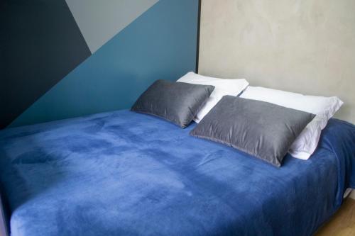 a blue bed with two pillows on top of it at Tiny House Urban in Balneário Camboriú