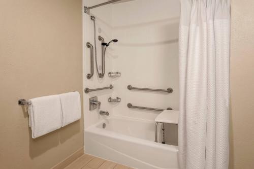 a bathroom with a tub and a shower with a shower curtain at Courtyard by Marriott San Antonio Airport/North Star Mall in San Antonio
