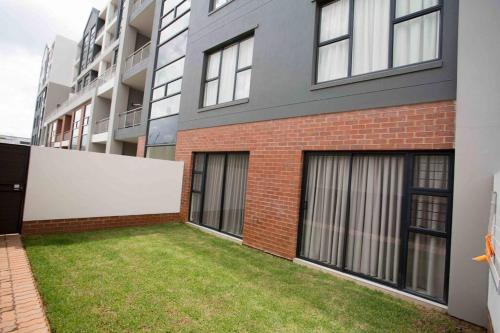 a brick building with a lawn in front of it at Secured and Fully equipped apartment- E in Lombardy East