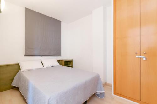 1 dormitorio con cama y pantalla grande en Apartamento con vista piscina, en Roses