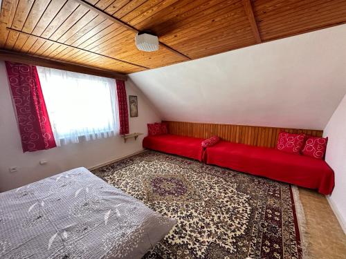 a living room with a red couch and a window at Ubytování u Přadků in Čeladná