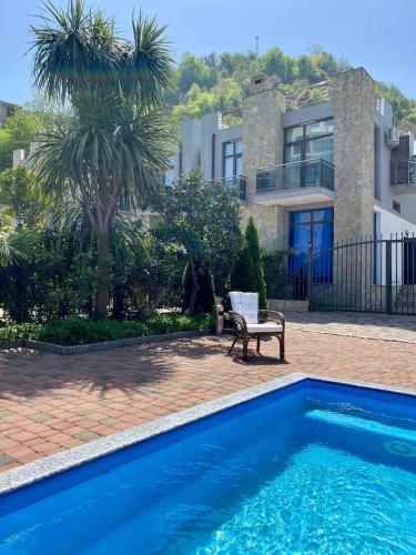 a house with a blue swimming pool in front of a house at European Village Old Villa 6 in Gonio