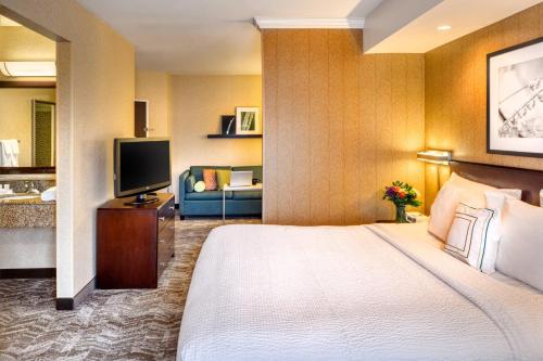 ソルトレイクシティにあるスプリングヒル スイーツ バイ マリオット ソルトレイク シティ ダウンタウンのベッドとテレビが備わるホテルルームです。