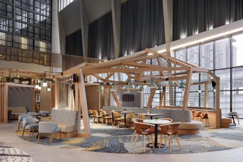 a lobby with tables and chairs in a building at Delta Hotels Calgary Airport In-Terminal in Calgary