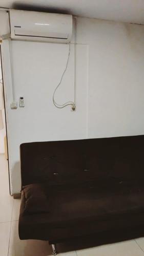 un sofá negro sentado junto a una pared blanca en Sombra, en Ciudad de la Costa
