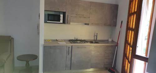 a small kitchen with a stove and a microwave at Villa Rosa in Latte