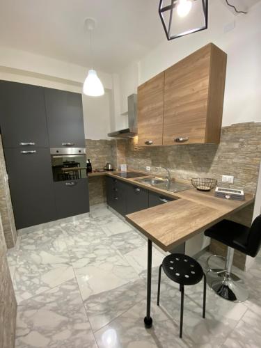 cocina con encimera de madera y fregadero en Ennio Rooms, en Bari