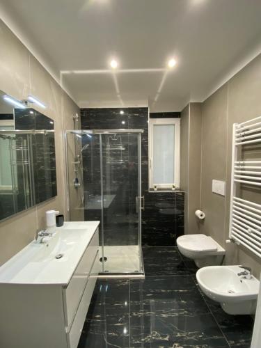 a bathroom with two sinks and a shower and two toilets at Ennio Rooms in Bari