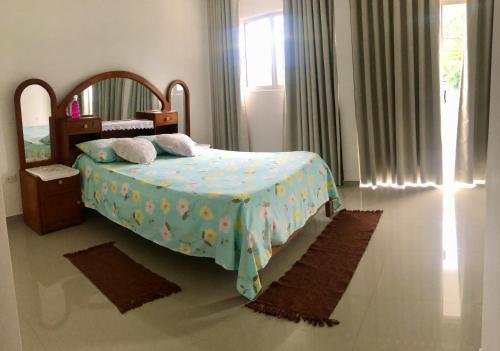 a bedroom with a bed with a blue blanket and a mirror at Casa Beni para estrenar in Santa Cruz de la Sierra