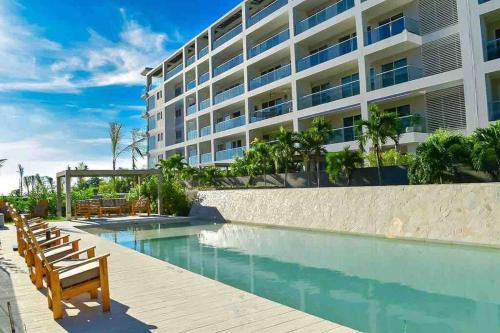 een zwembad met stoelen en een gebouw bij Fantastic Loft/Beachfront+Pools in Cartagena