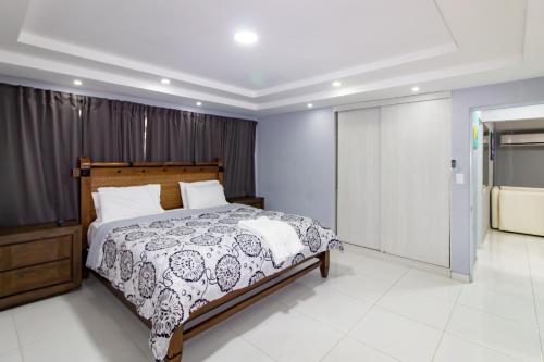 a bedroom with a bed with a black and white comforter at Hotel Señorial in Santo Domingo